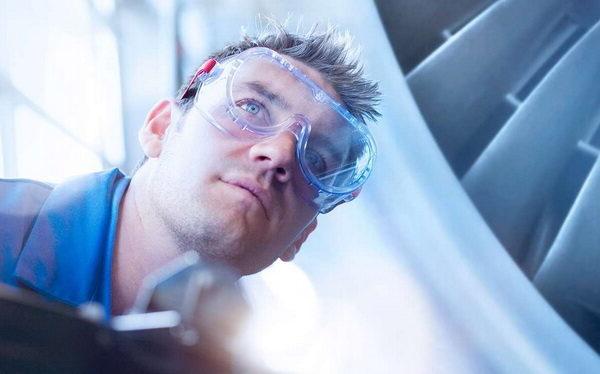 man in clear googles working on a plane